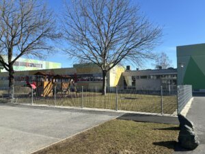 Auf dem Bild ist die Sonderschule Oberwart zu sehen. Im Vordergrund befindet sich ein Spielplatz.
