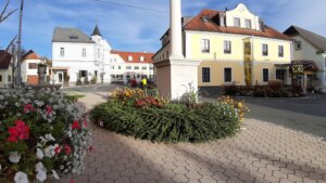 Hauptplatz Grafendorf mit gelben Rathaus im Blick und Blumenschmuck verziert.