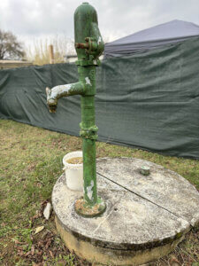 Ein alter Brunnen mit Pumpe.