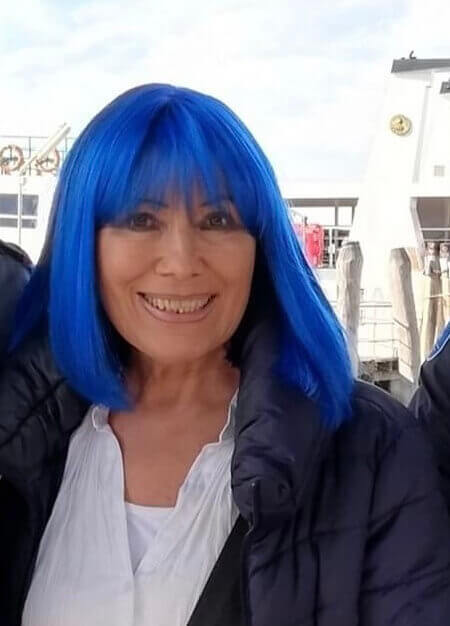 Trude Meichenitsch mit ihrer blauen Perücke lächle in die Kamera