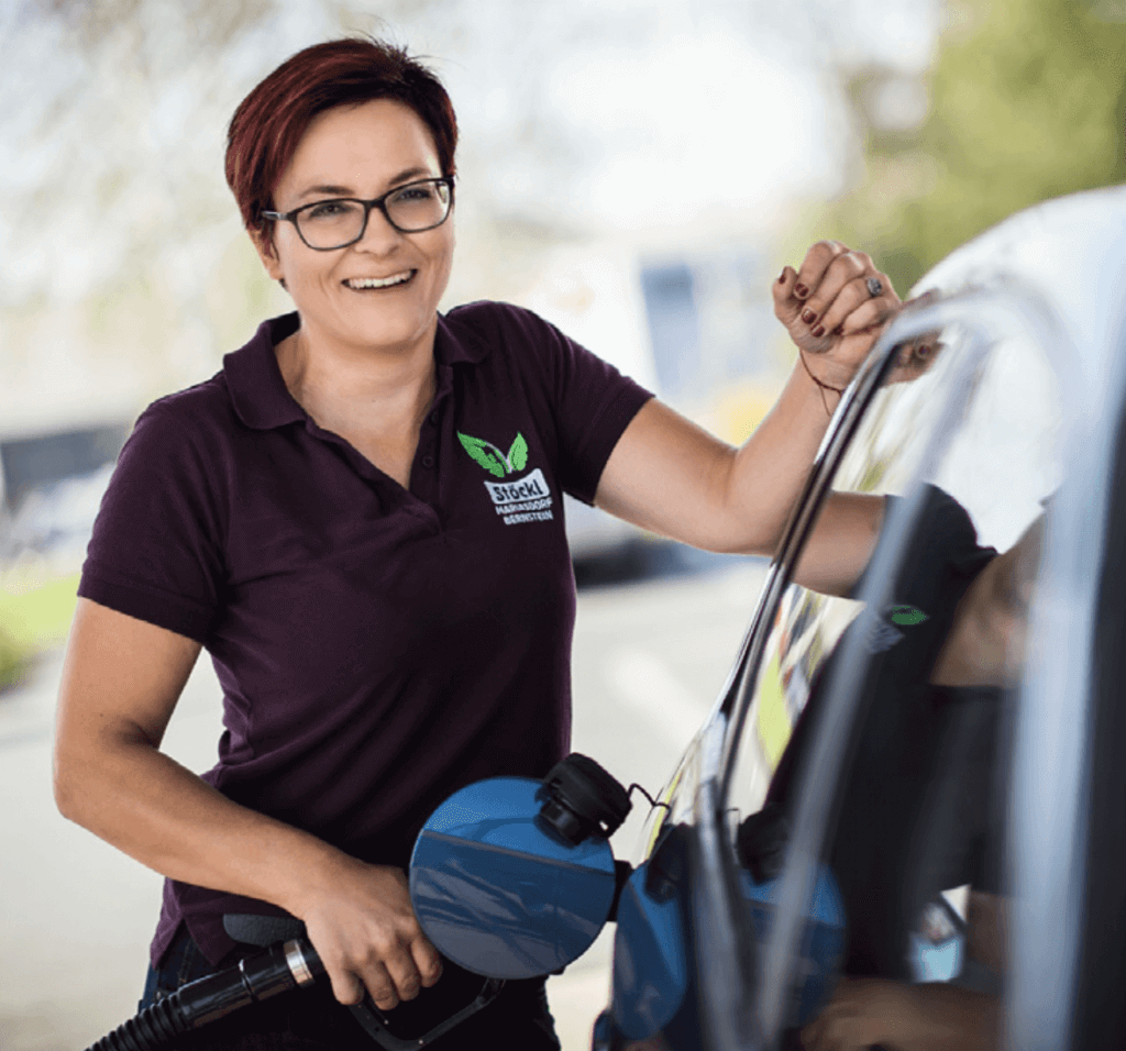 Porträt Tanja Stöckl mit Tankzapfhahn beim Tanken