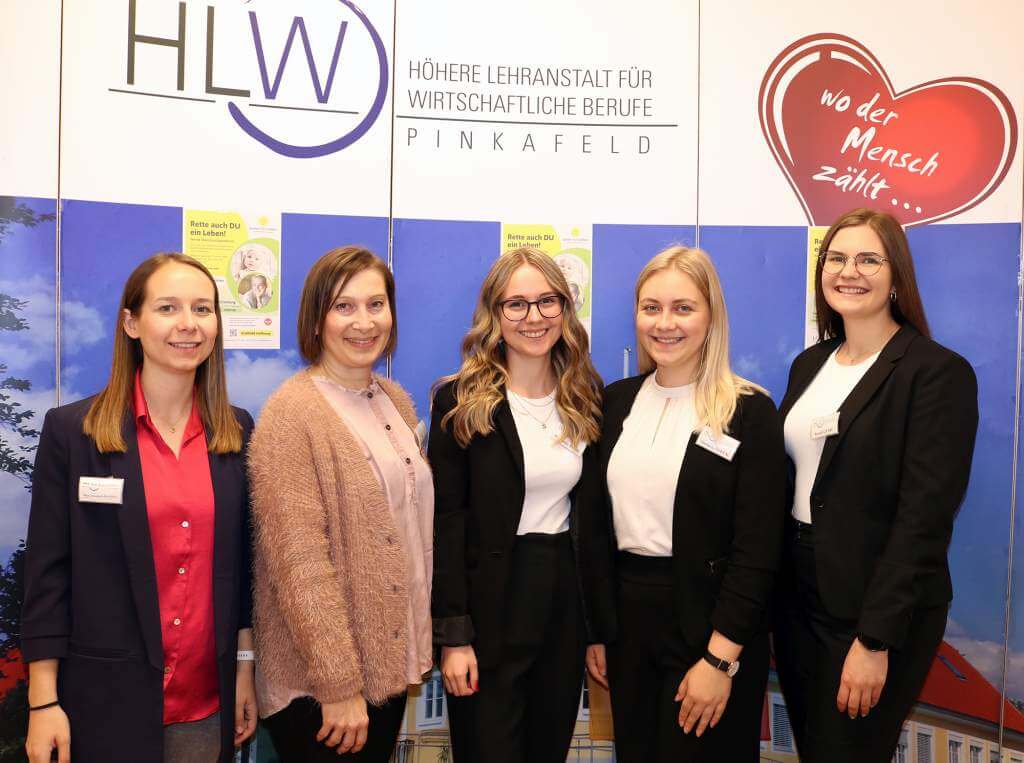 Vertreterinnen der HLW Pinkafeld stehen vor dem Roll-Up mit dem Schul-Logo. Es sind fünf Damen, die in die Kamera lächeln