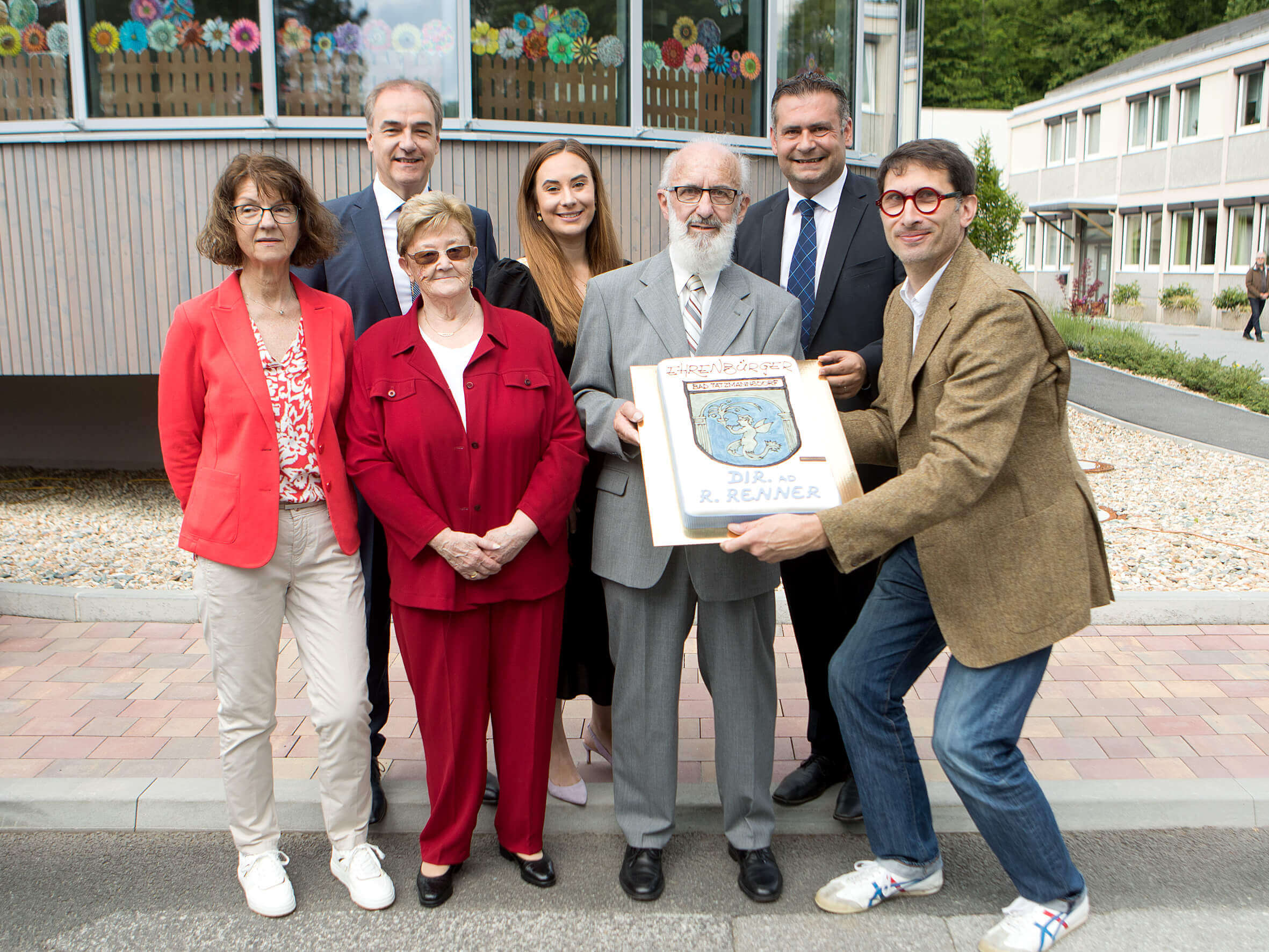 Der ehemalige Volksschuldirektor Ronald Renner erhielt von der Gemeinde die Ehrenbürgerschaft verliehen. Landesrat Dr. Leonhard Schneemann (links hinten) gratulierte gemeinsam mit Vizebürgermeisterin Christine Kotschar und Bürgermeister Stefan Laimer (hinten v.l.). Mit ihnen vorne am Foto: Volksschuldirektorin Marlies Gesslbauer und Konditormeister Christian Kaplan, der Ronald und Gattin Christa Renner (Mitte) eine Tore überreichte.