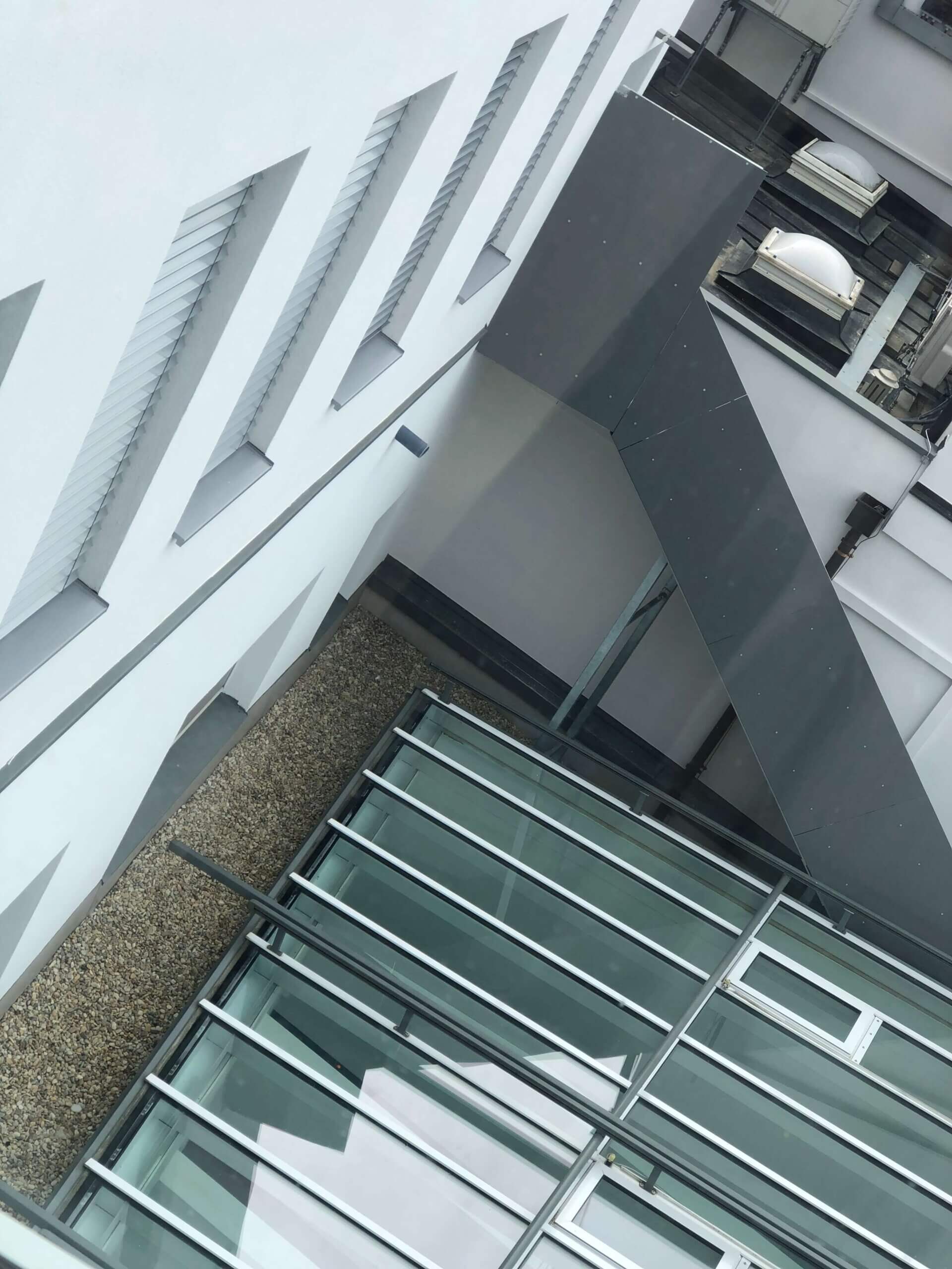 Ein Blick aus einem Fenster in der Raiffeisenbank Oberwart. Zu sehen ist ein Innenhof mit einem Glasdach und Lüftungsanlagen an den Wänden des Gebäudes.