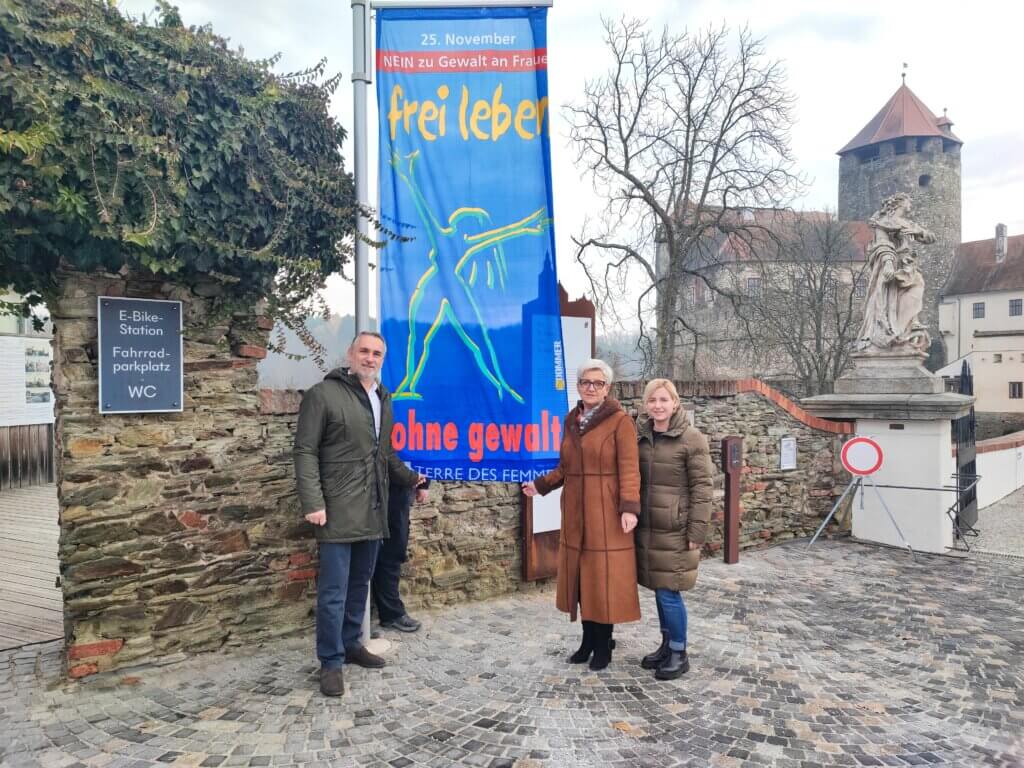 1000283832 Menschen vor einem Banner gegen Gewalt an Frauen, 25. November, Schloss im Hintergrund.