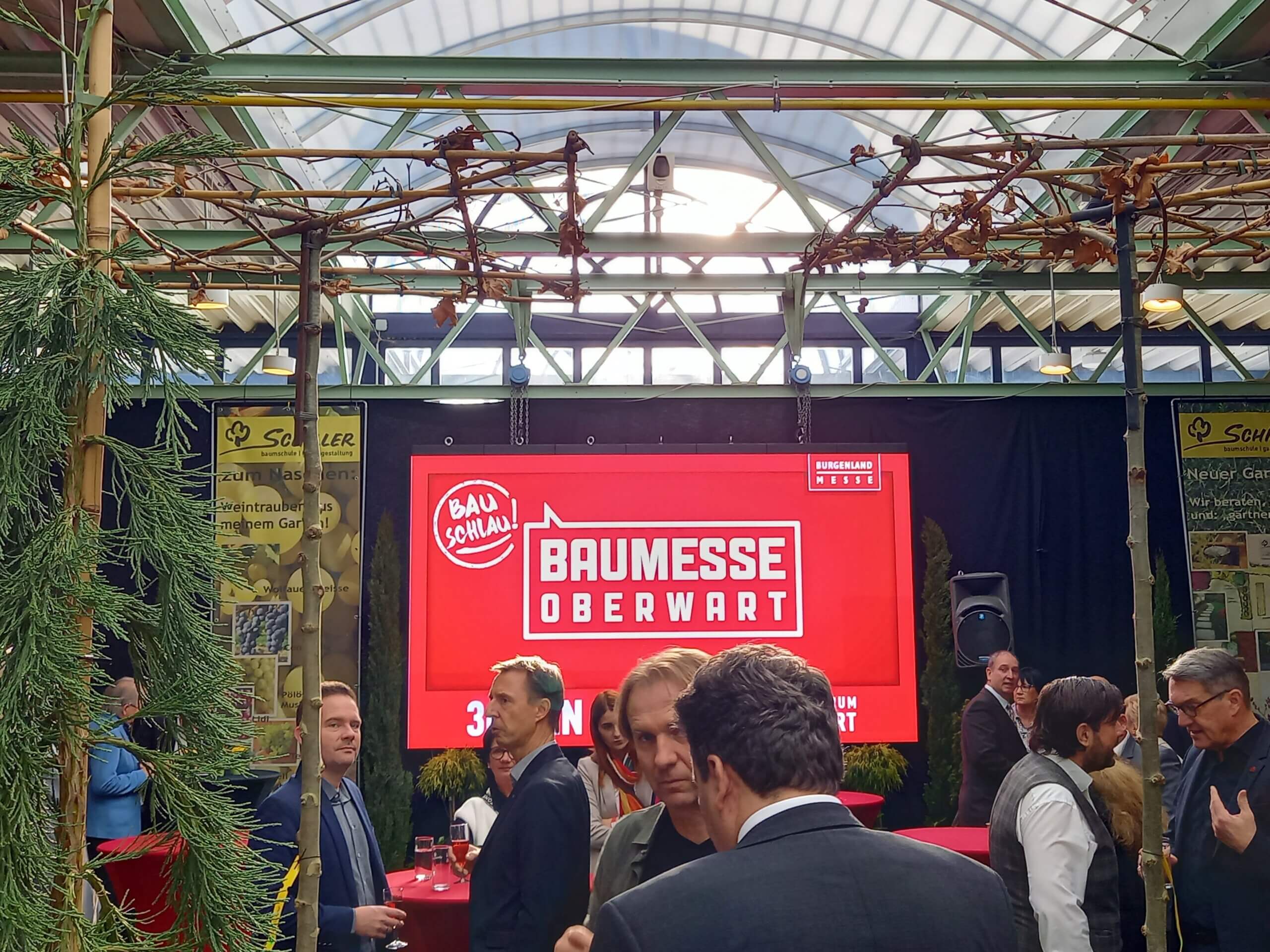 Menschen versammeln sich auf der Baumesse Oberwart vor einem großen Bildschirm.