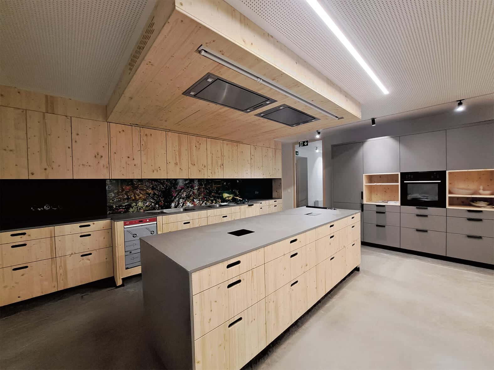 Moderne Küche mit Holz- und Grauelementen, Insel und Einbaugeräten in elegantem Design.