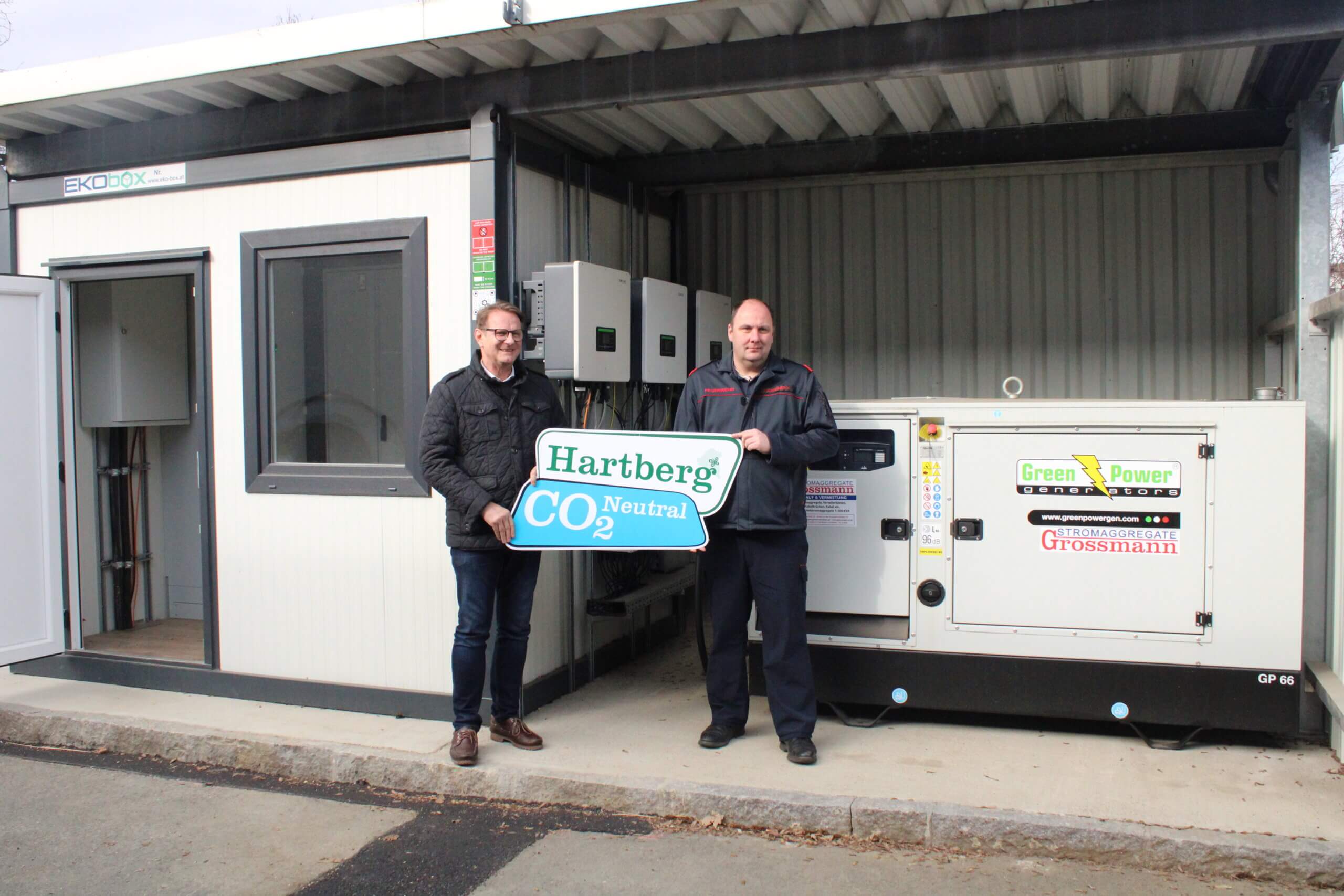 Zwei Männer präsentieren ein CO2-neutrales Green Power Stromaggregat in Hartberg.