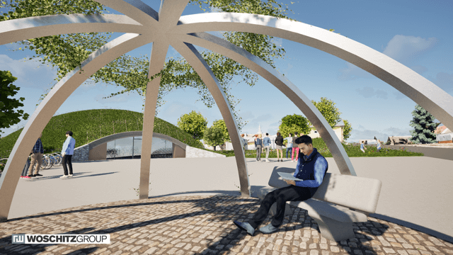 Moderner Park mit Bänken und Kuppelstruktur, ein Mann liest im Schatten, grüne Landschaft im Hintergrund.