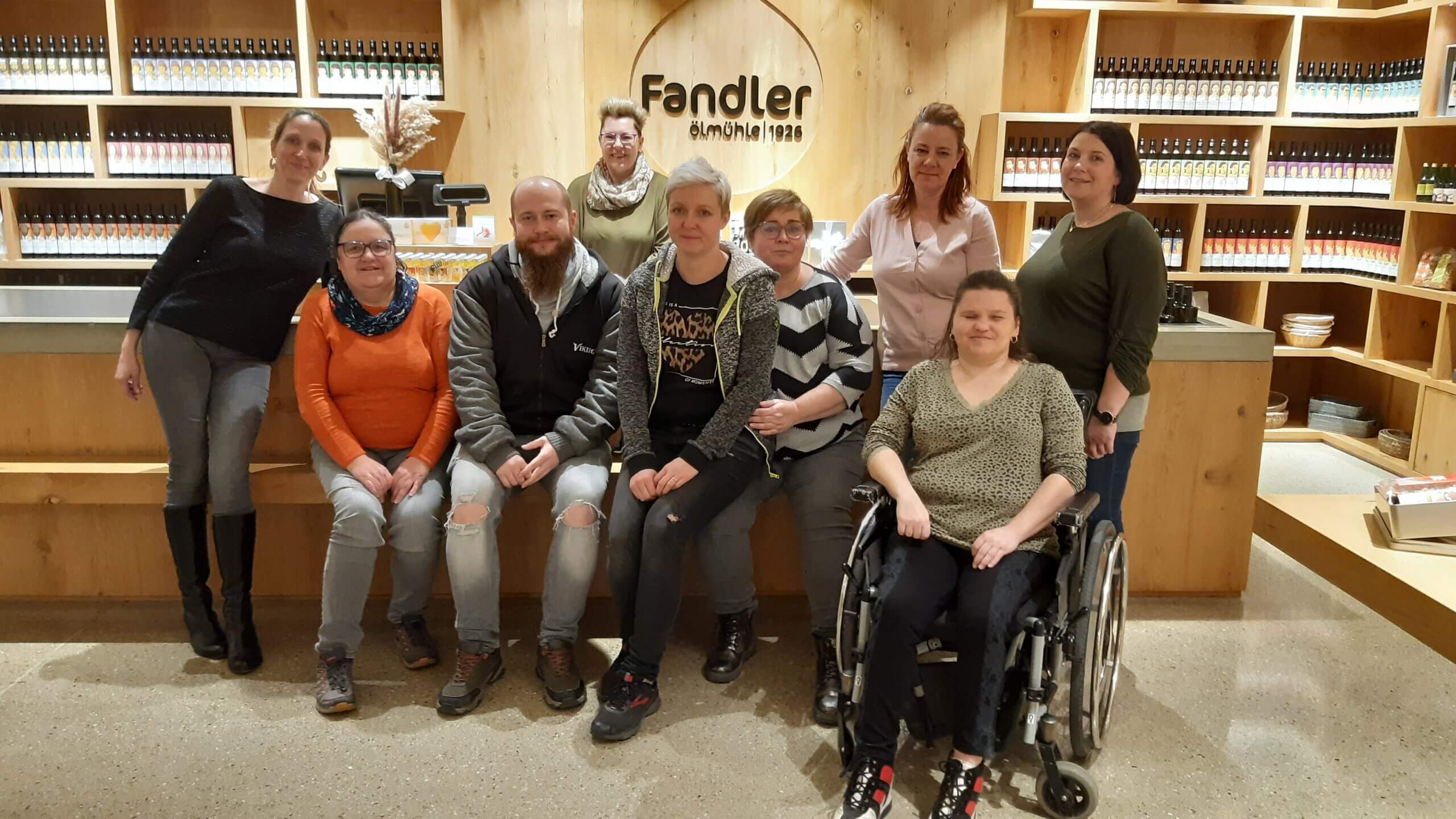 Eine Gruppe von Menschen posiert vor einem Fandler Ölmühle 1926 Schild in einem Holzeinrichtungsladen.