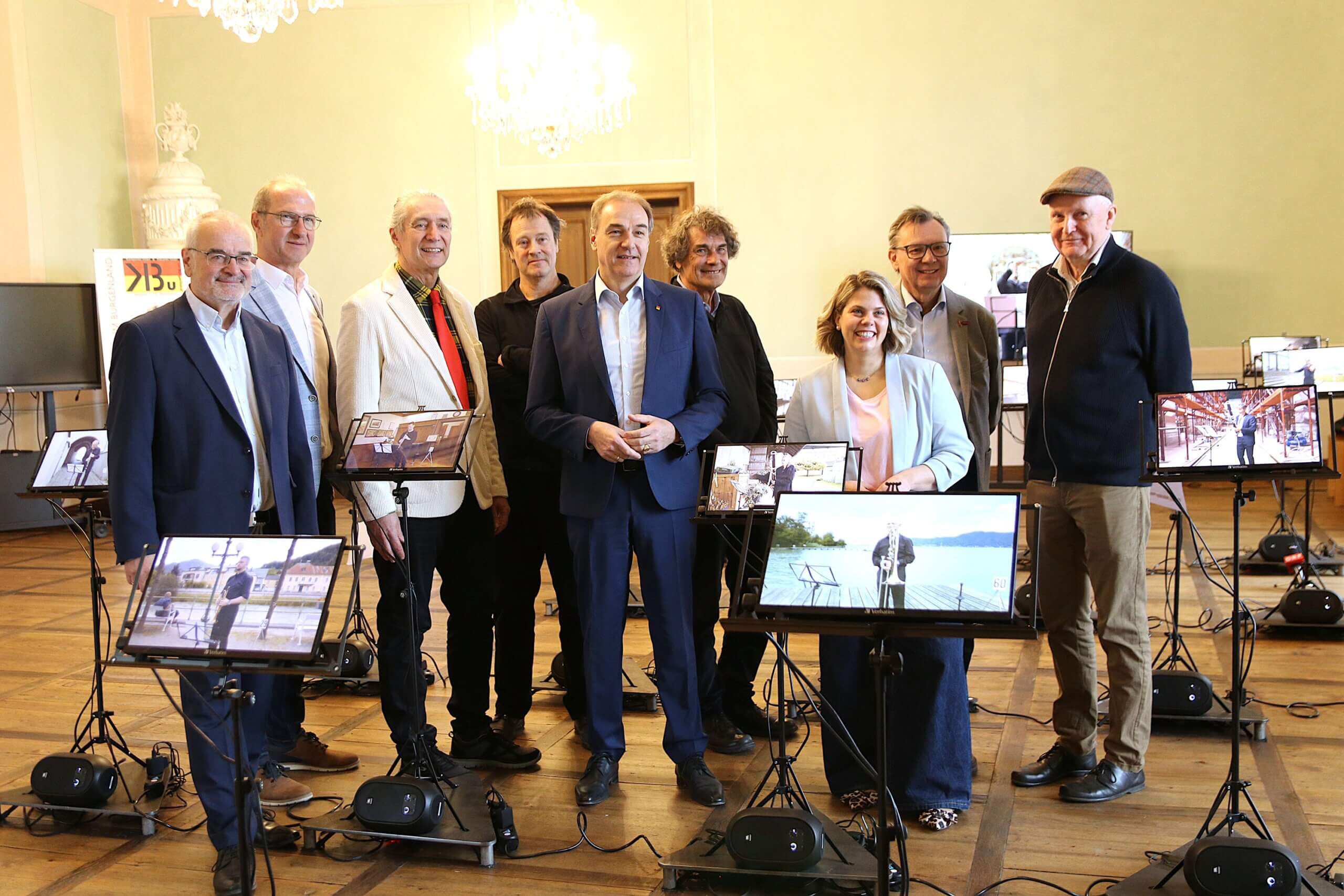 Gruppe von Personen posiert mit digitalen Displays in einem eleganten Raum bei einem Event oder Meeting.