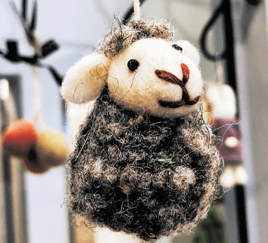 Filz-Schafanhänger mit niedlichem Gesicht und grauem Fell, hängend an einer Schnur; Dekoratives Handwerk.