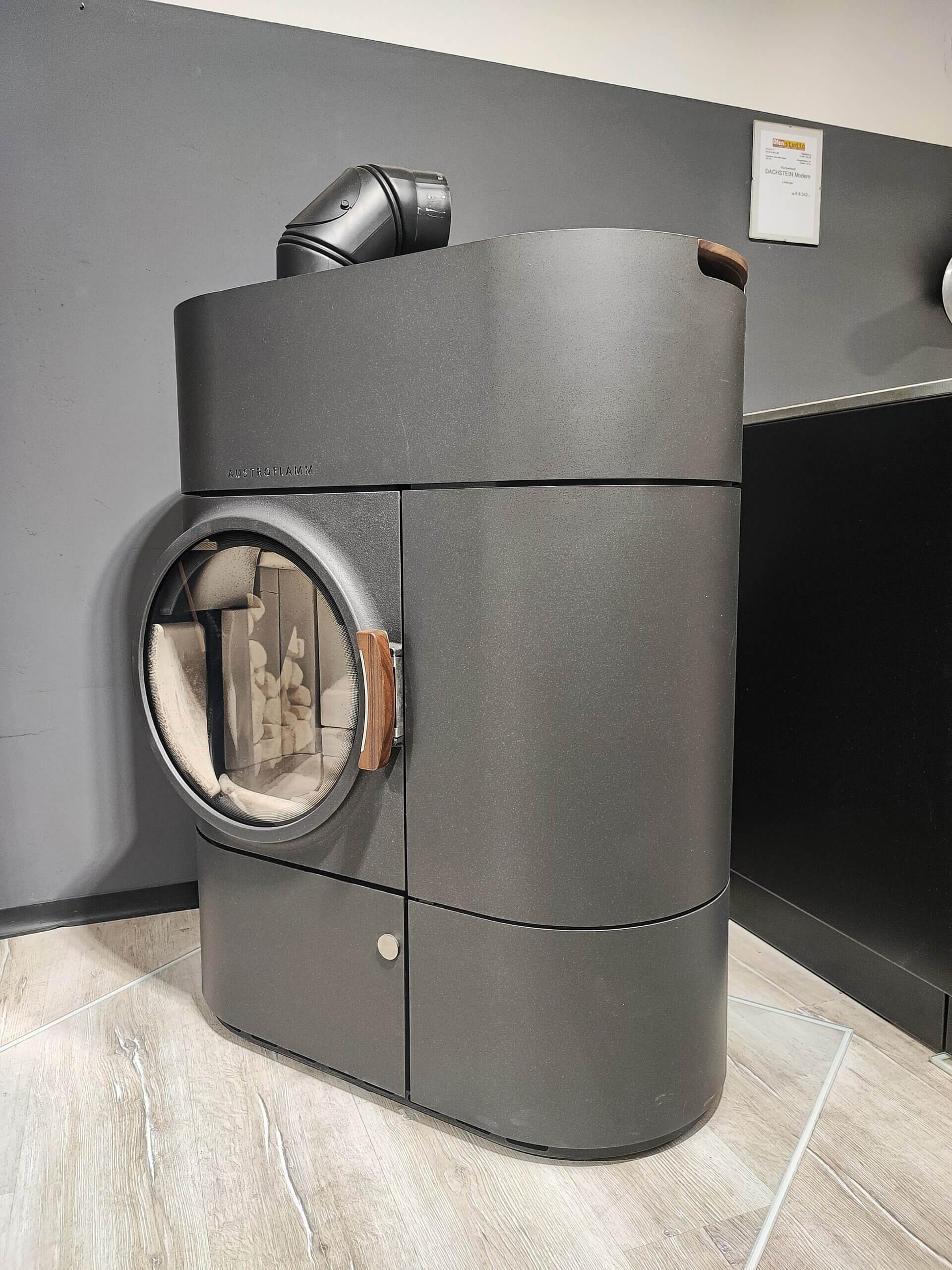 Moderne schwarze Pelletheizung mit sichtbarem Brennraum, ideal für umweltfreundliches Heizen in stilvollen Räumen.