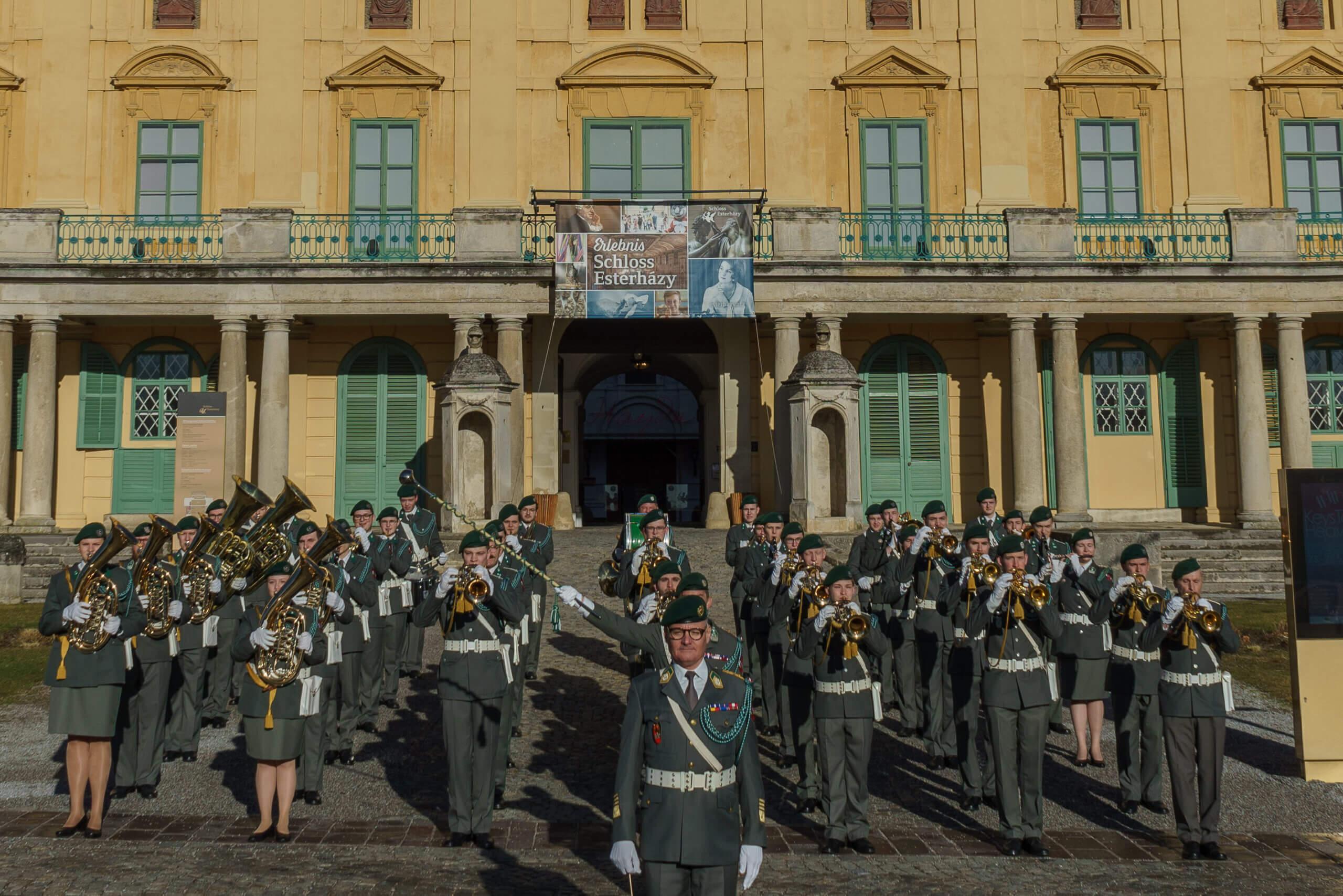 Militärkapelle spielt vor Schloss Esterházy, Eisenstadt, an einem sonnigen Tag. Musiker in Uniform mit Blasinstrumenten.