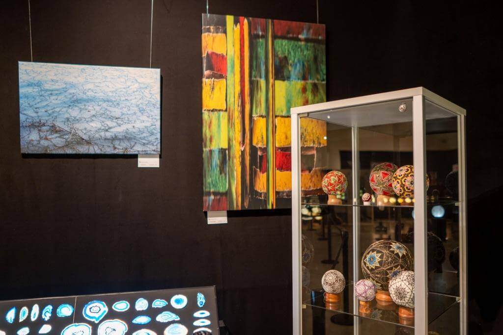 Kunstgalerie mit Gemälden und Vitrinen mit kunstvollen Kugeln ausgestellt.