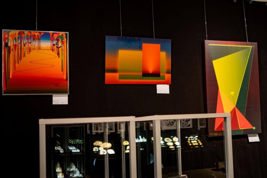 Innovative abstrakte Kunstwerke in kräftigen Farben in einer Galerieausstellung, beleuchtet und inspirierend.