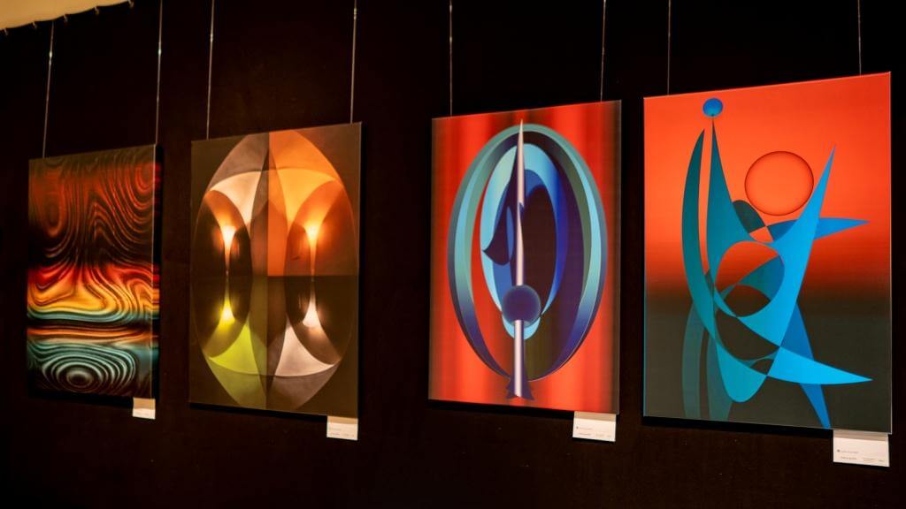 Abstrakte Kunstwerke in Galerieausstellung, leuchtende Farben und geometrische Formen auf Leinwänden.