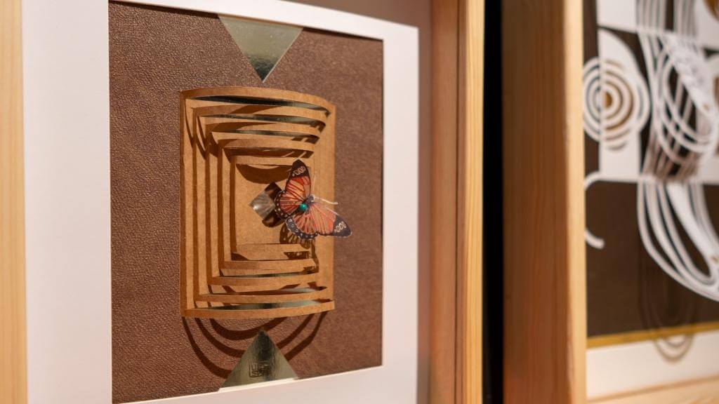 Papierkunst mit Schmetterling: Geometrische 3D-Designs in Holzrahmen, moderner Kunststil in warmer Beleuchtung.