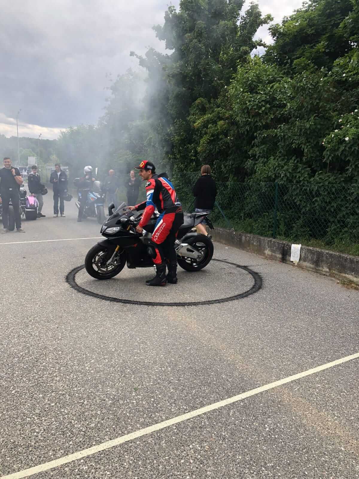 Motorradfahrer macht Driftstunt in rauchiger Umgebung auf der Straße.