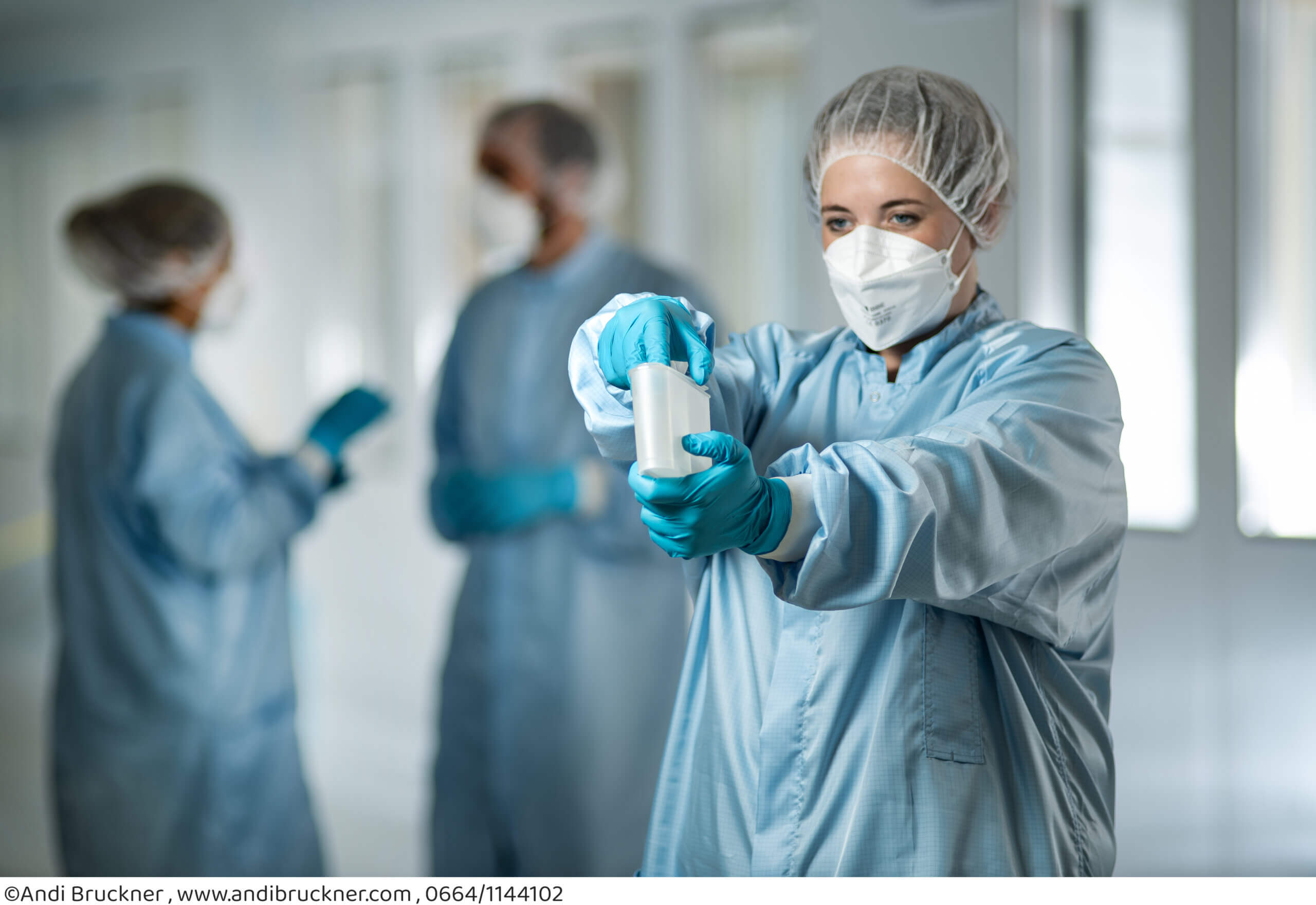 Wissenschaftler im Labor prüfen Proben in Schutzkleidung, Fokus auf Laborarbeit und Sicherheit.