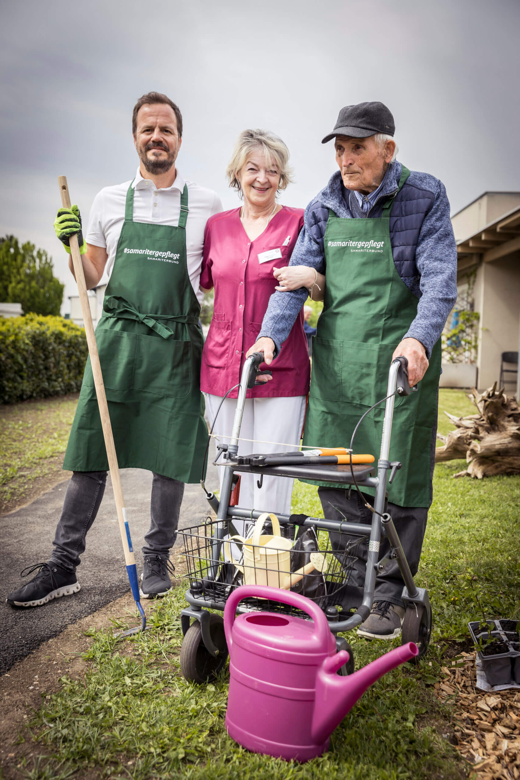 Seniorenpflege im Garten: Betreuerin mit Senioren beim Gärtnern im Freien. Unterstützung und Freude in der Natur.