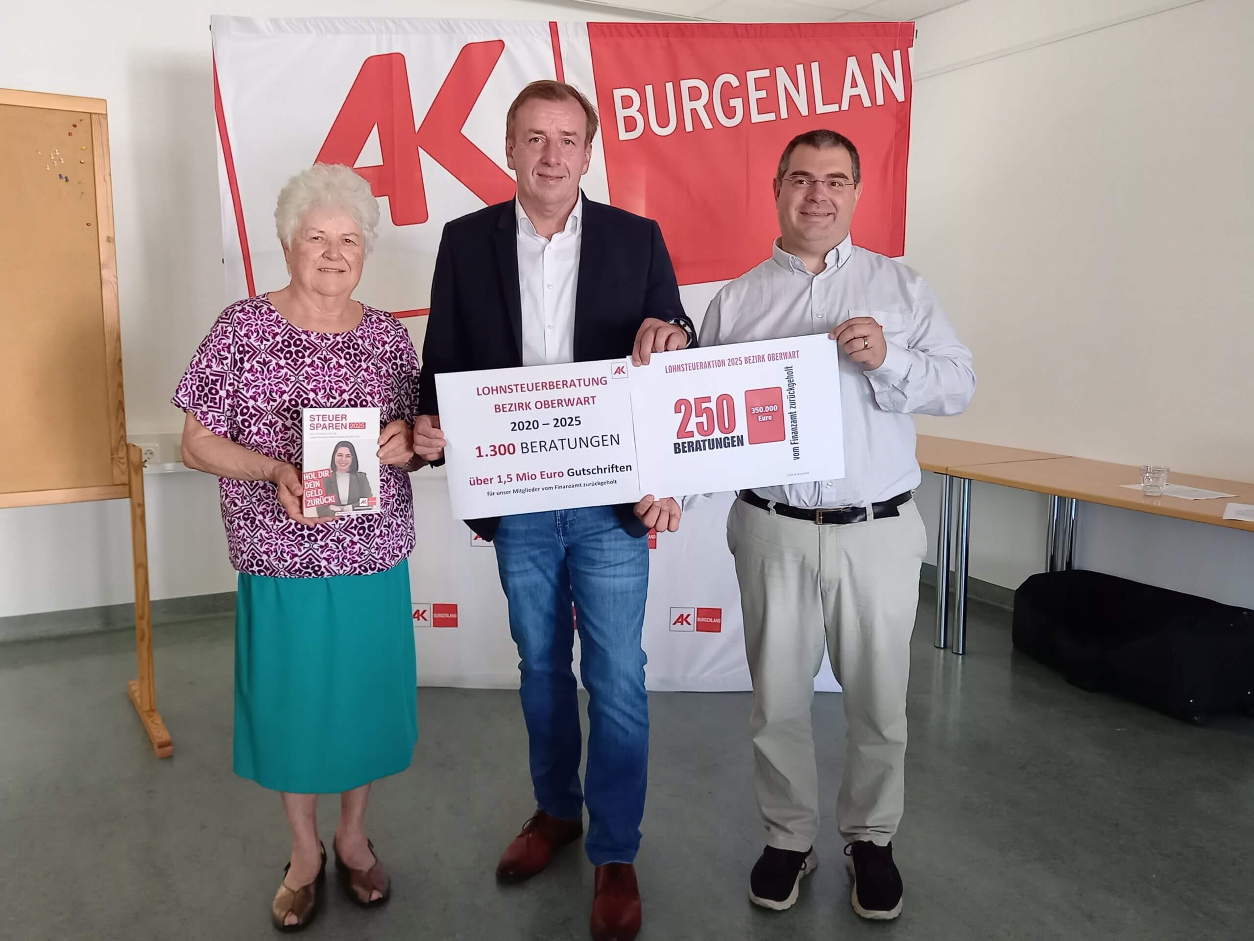 Drei Personen bei AK Burgenland Event zur Lohnsteuerberatung, halten Plakate mit Beratungzahlen und Beiträgen.