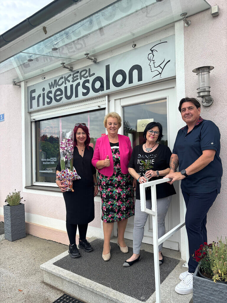 IMG_4131©Pieler Chiara Vier Personen stehen vor dem Wickerl Friseursalon, lächeln und feiern eine Veranstaltung.