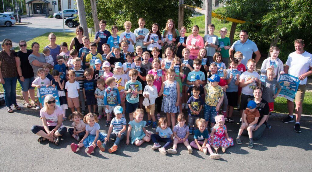 Gruppe von Kindern und Erwachsenen beim Lesesommer Burgenland 2023, lächelnd und Urkunden in der Hand.
