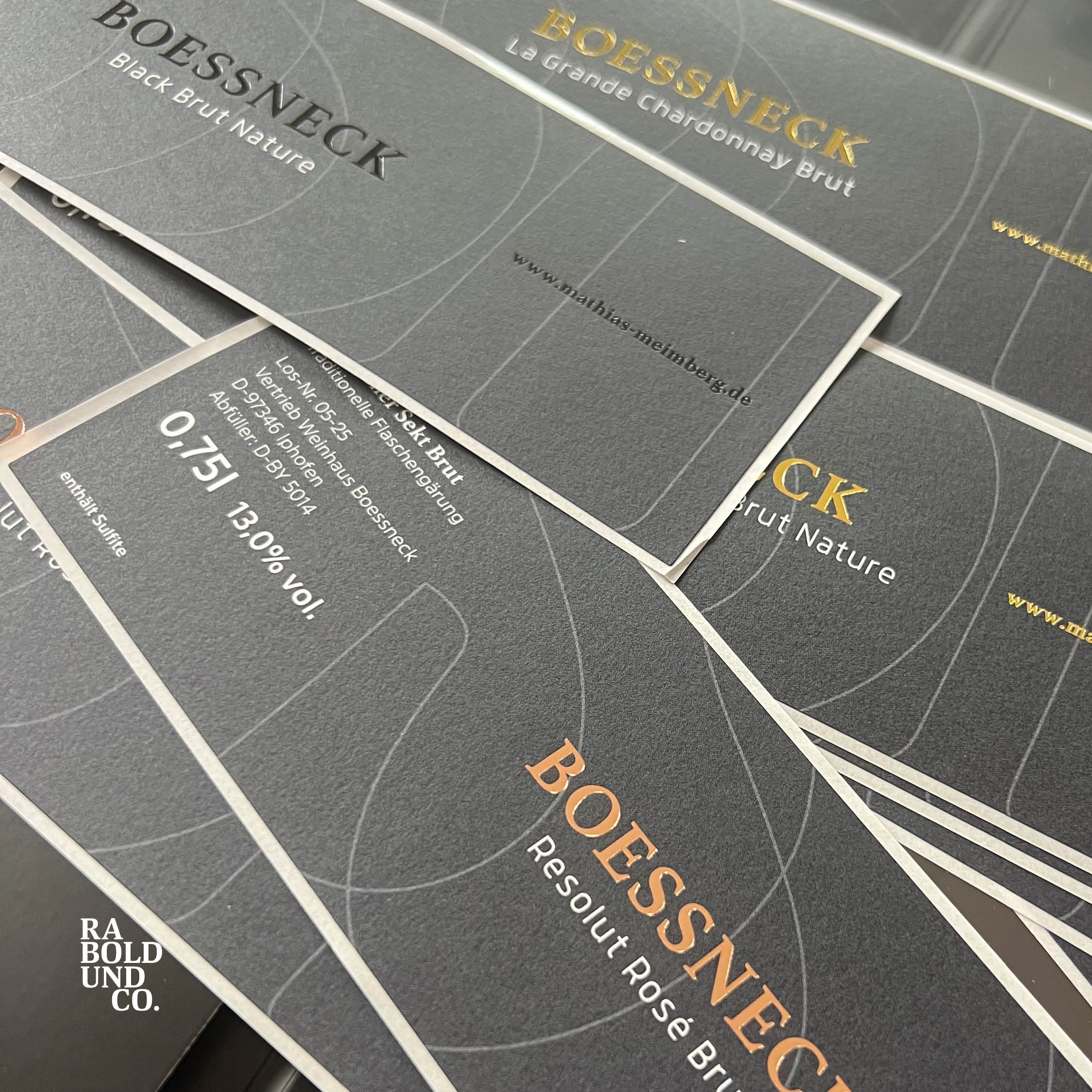 Schwarze Weinetiketten von Boessneck, verschiedene Sorten, elegant gestaltet, Fokus auf Brut Nature.