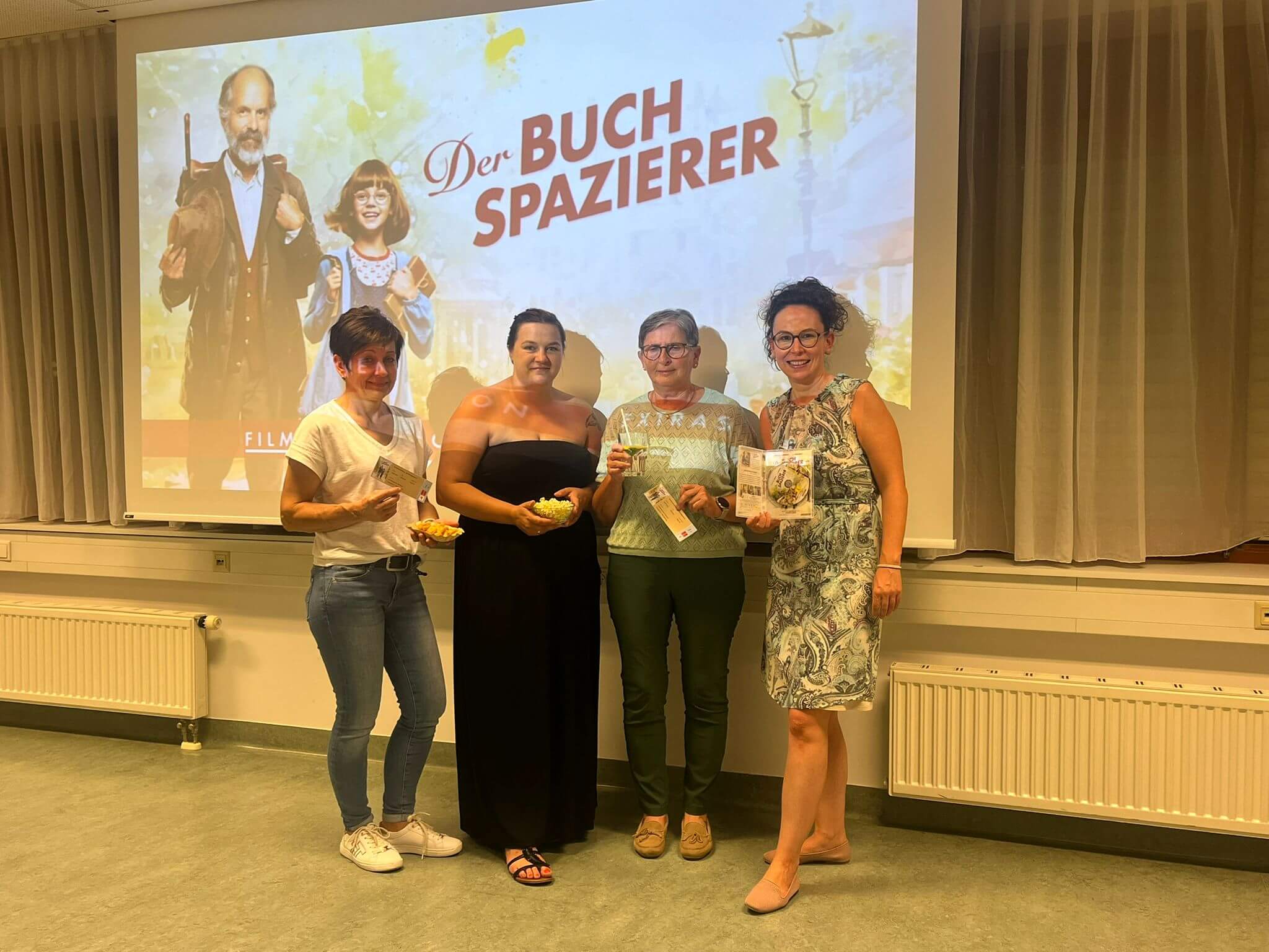 Vier Frauen bei der Premiere von Der Buchspazierer mit Projektor im Hintergrund.