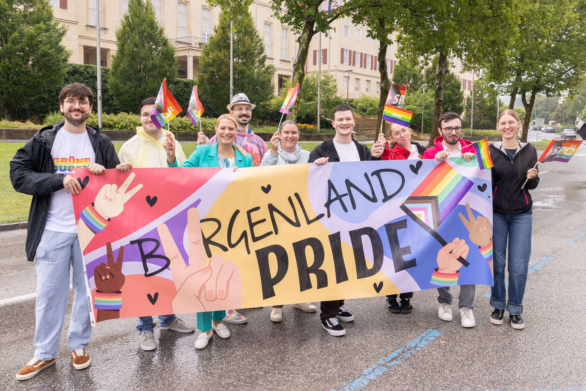 Gruppe hält Burgenland Pride-Banner, zeigt Regenbogenflaggen, feiert Vielfalt und Inklusion auf einer Parade.