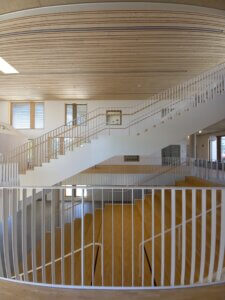 Moderne Architektur im Innenraum: Holzverkleidung und weiße Treppen im minimalistischen Design eines Gebäudes.