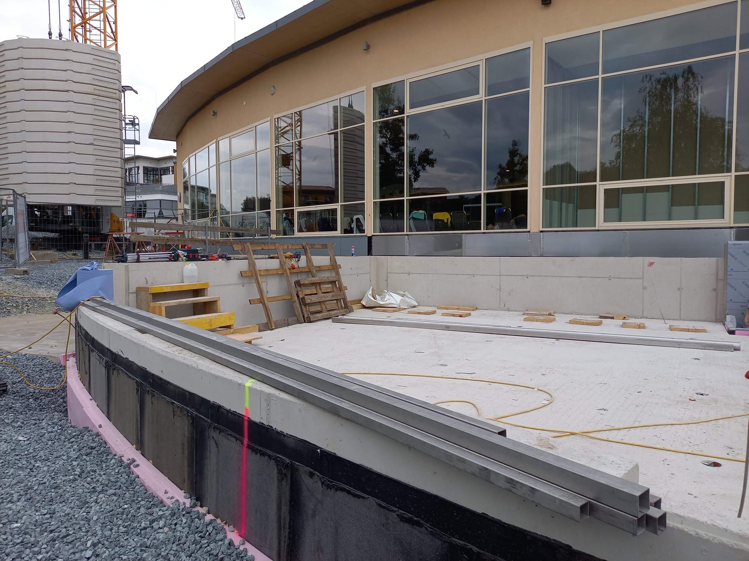 Baustelle mit Kran und modernem Gebäude im Hintergrund, Bausektor und Renovierungsarbeiten, Außenbereich.