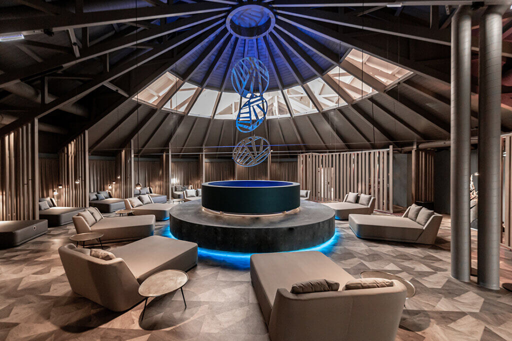 Avita2024-7537b©AVITA Resort Moderner Wellnessbereich mit runden Sofas und stimmungsvoller Beleuchtung unter Kuppeldach.