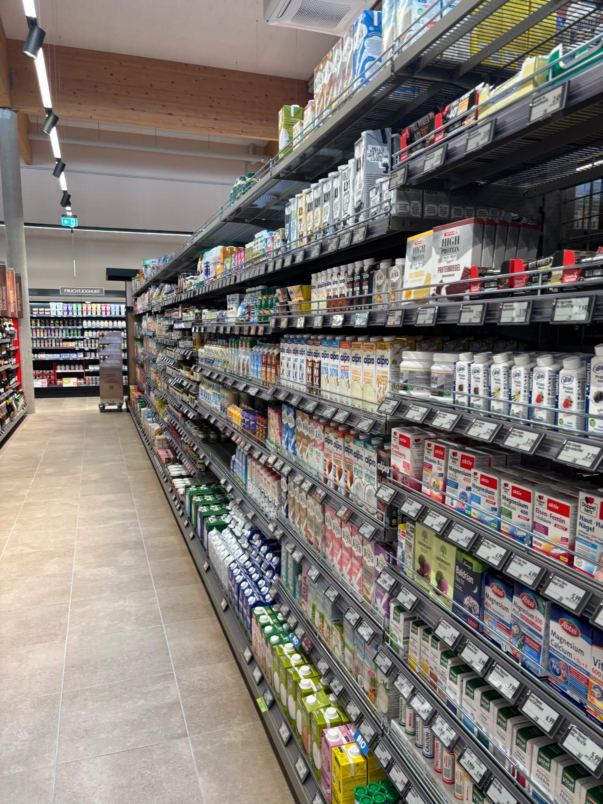 Supermarktregal voller Getränke und Nahrungsergänzungsmittel, gut sortiert in moderner Ladenumgebung.