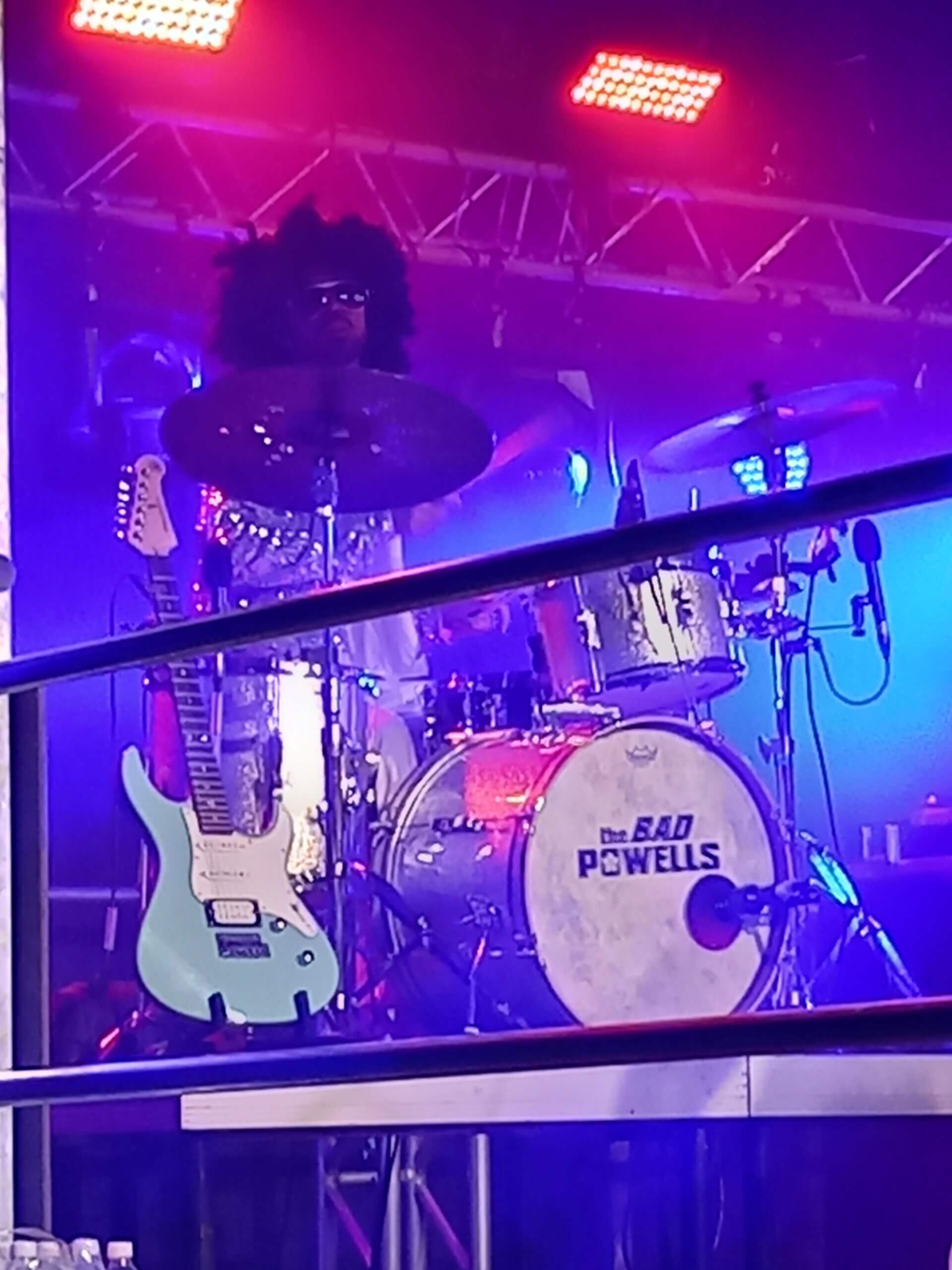 Schlagzeuger in bunter Beleuchtung auf der Bühne bei einem Konzert der Band The Bad Powells.