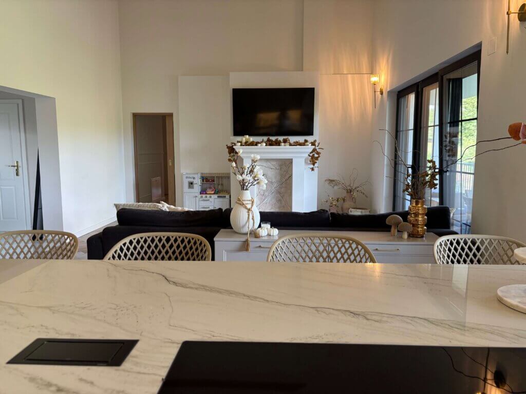 Moderne Wohnzimmereinrichtung mit Kamin, großem Fernseher und stilvollen Dekorationen für ein gemütliches Ambiente.