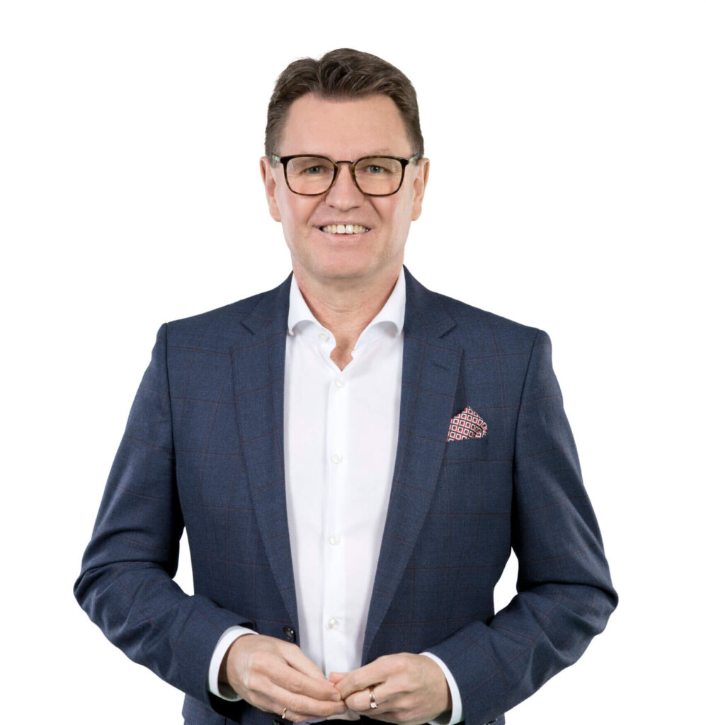 Geschäftsmann im Anzug lächelt professionell, isoliert vor weißem Hintergrund.
