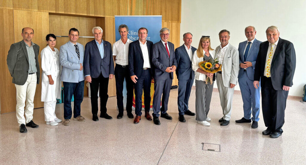 Gruppe von Personen feiert ein Ereignis im Klinikum Oberwart, Österreich, mit einem Blumenstrauß.