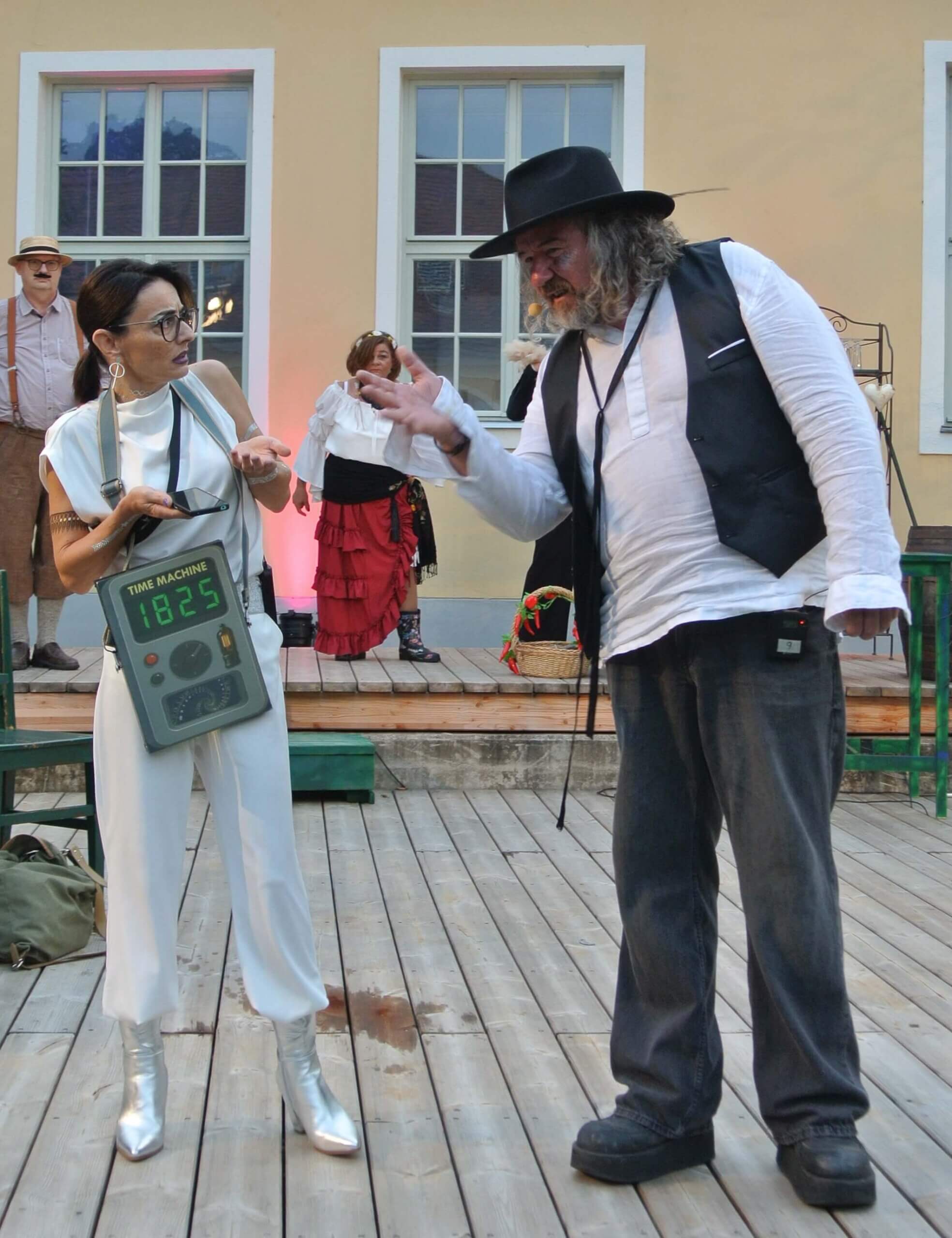 Theaterszene mit Zeitmaschine aus dem Jahr 1825: Schauspieler in historischen Kostümen auf Holzbühne.
