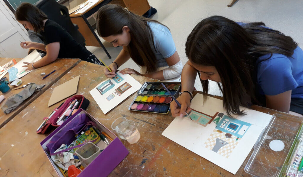 Kinder in einer Kunstklasse malen mit Aquarellen, um Kreativität und Handwerkskunst zu fördern.