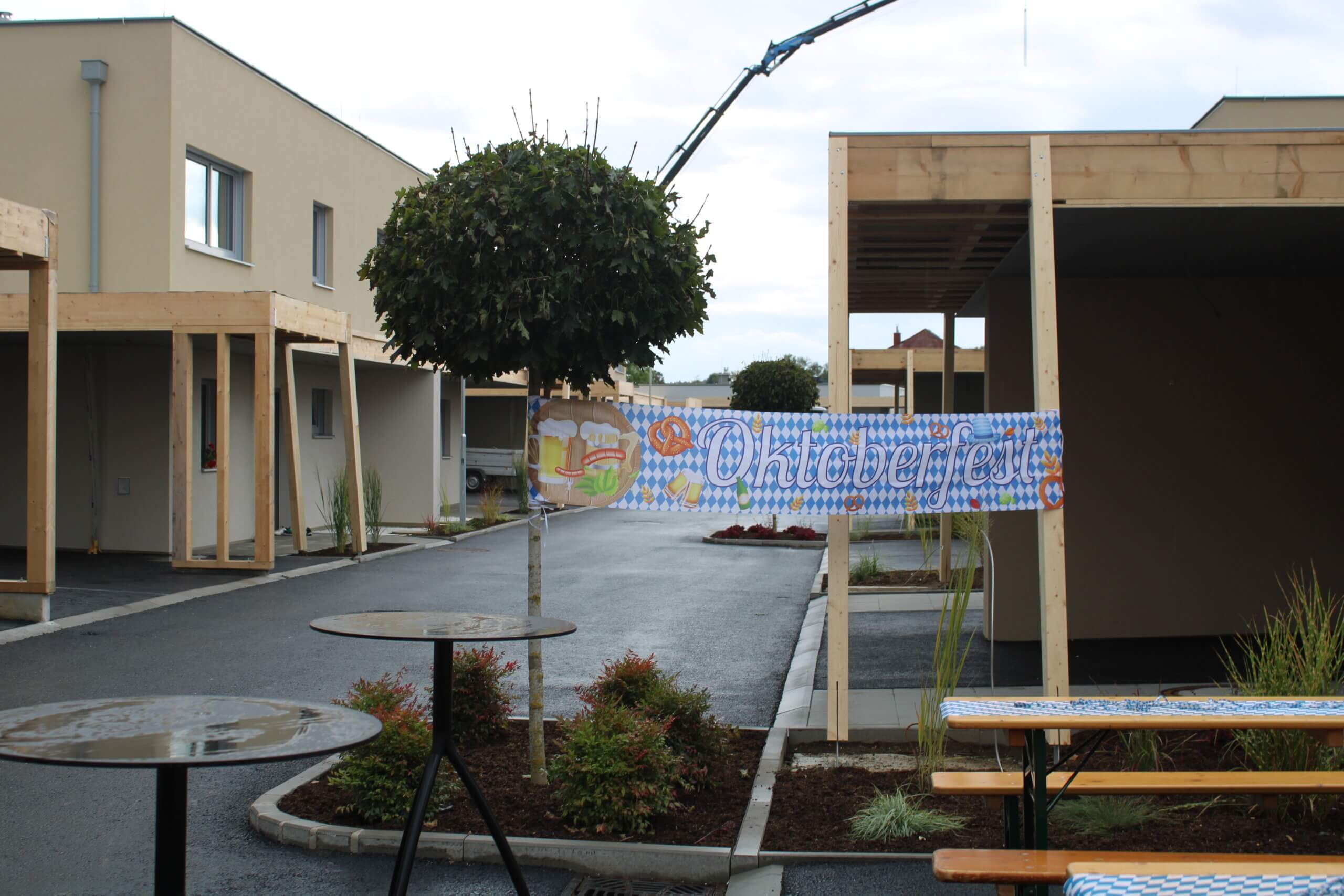 Oktoberfest-Dekoration mit Banner und Bierzeltgarnitur in moderner Nachbarschaft, beschrieben im Prima Magazin.