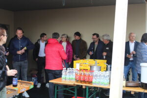 Personengruppe bei geselligem Treffen mit Getränken und Snacks in lockerer Atmosphäre, geeignet für regionales Magazin.