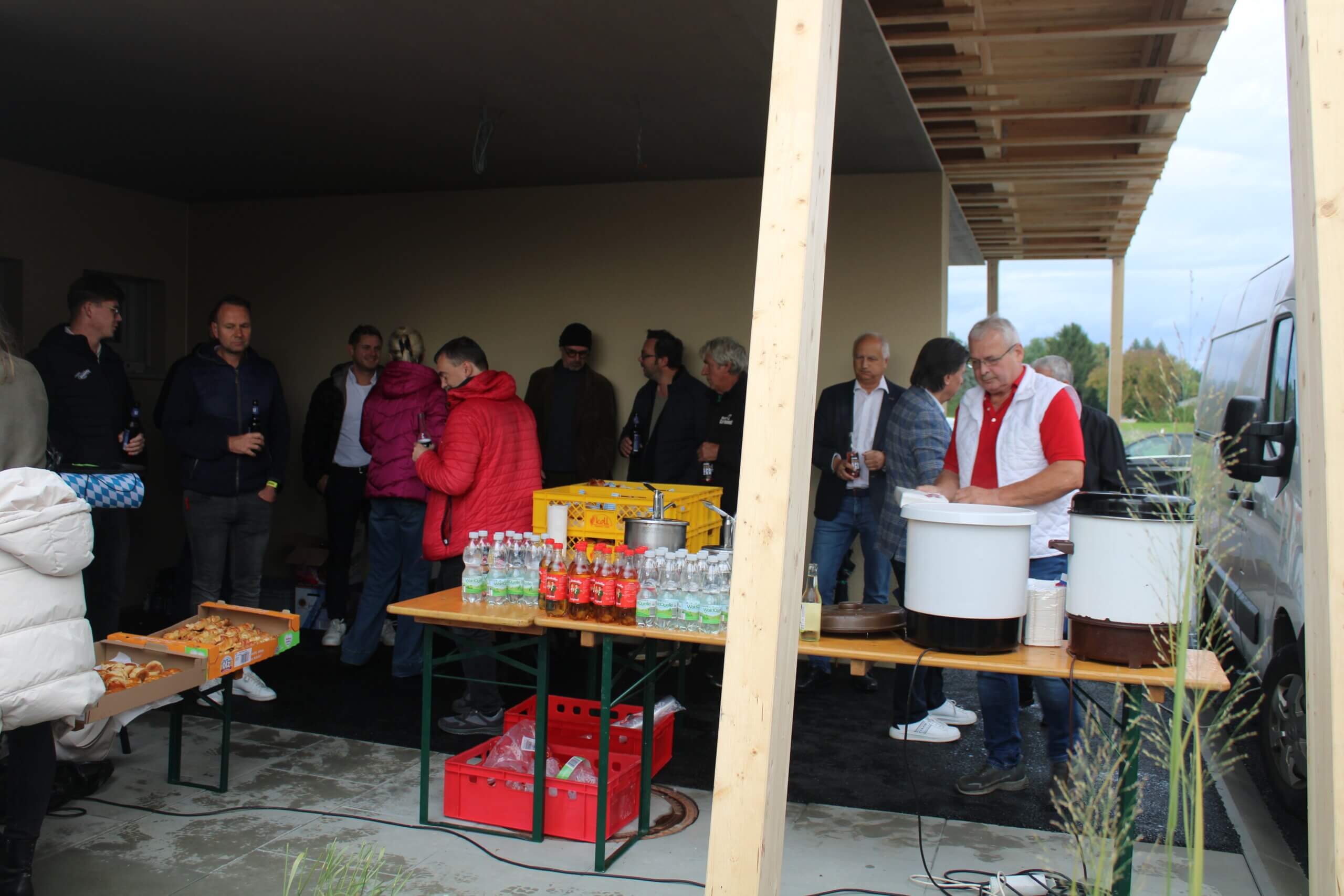 Menschen bei einer entspannten Grillparty mit Getränken und Snacks, im Freien versammelt, passend für Prima Magazin.