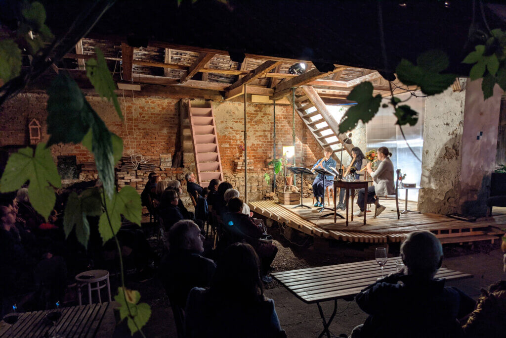 Ein Kammermusikkonzert in rustikalem Ambiente zieht ein interessiertes Publikum in einer alten Scheune an.