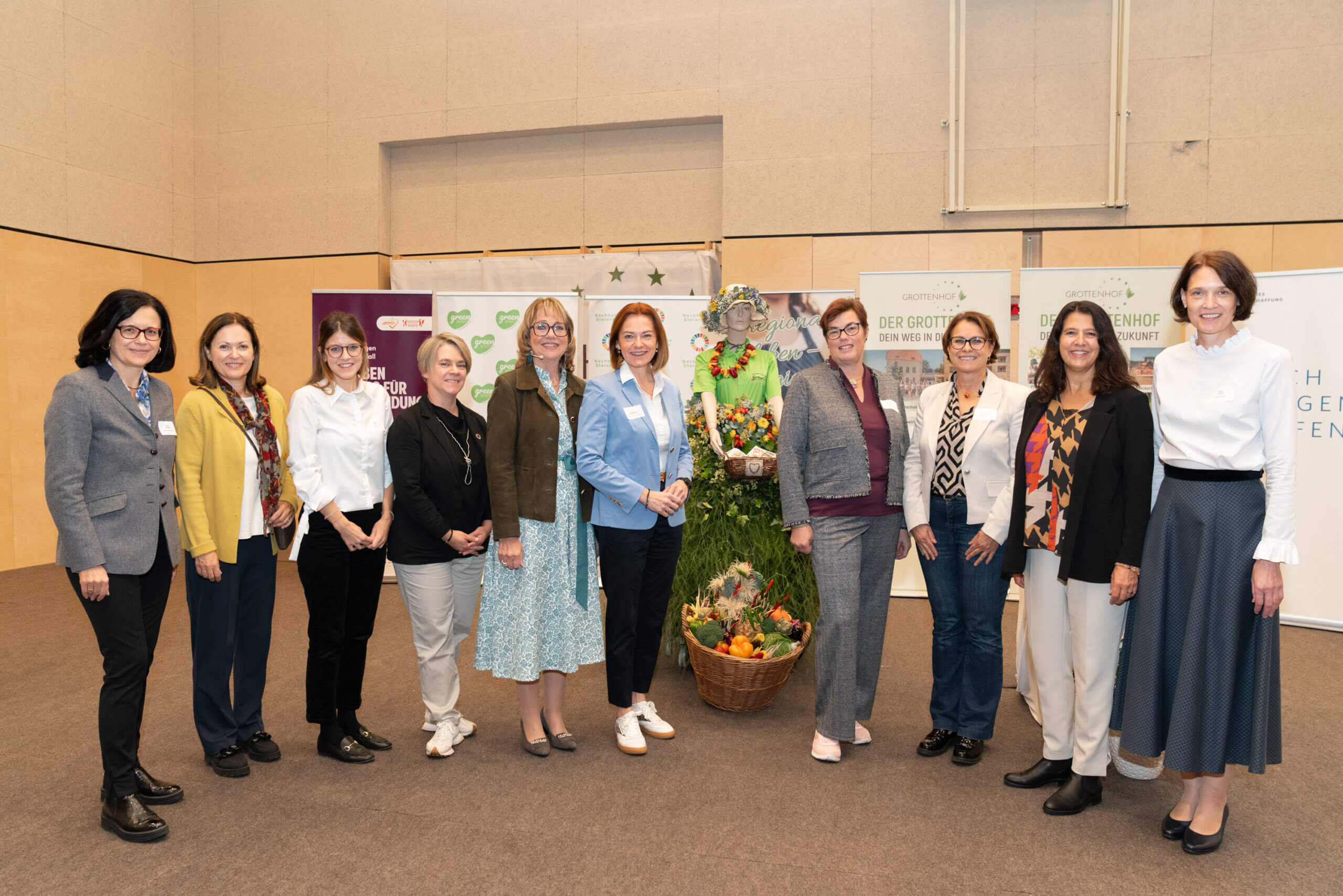 Gruppe von Frauen posiert bei einer Veranstaltung vor Bannern eines regionalen Magazins mit Erntekorb im Vordergrund.