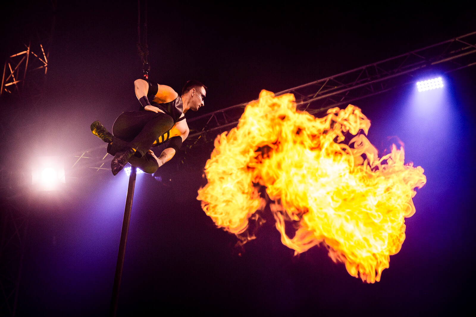Akrobat in der Luft zeigt spektakuläre Feuershow, aufgenommen auf einer regionalen Veranstaltung im Prima Magazin-Stil.