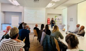 Ein Workshop des Prima Magazins: Vortragende Frau erklärt Content-Strategien vor interessiertem Publikum in modernem Seminarraum.