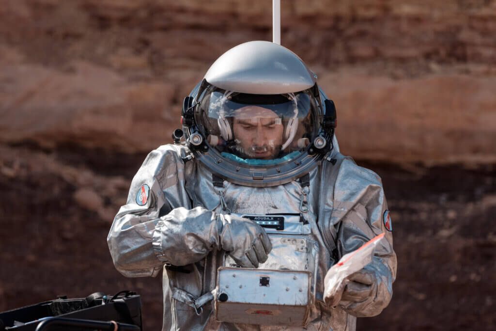 Astronaut in silbernem Raumanzug erkundet felsige Marslandschaft, Fokus auf innovativer Weltraumforschung für Prima Magazin.