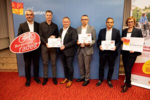 Gruppe von sieben Personen präsentiert Burgenland radelt Schilder und Urkunden bei einer Veranstaltung im Burgenland.